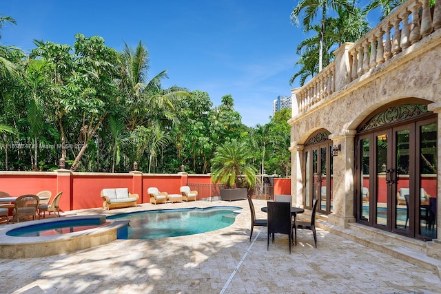 view of swimming pool featuring french doors, a patio, and an in ground hot tub