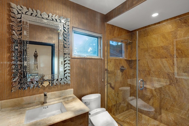 bathroom featuring toilet, wood walls, walk in shower, and vanity