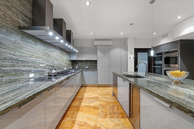 kitchen featuring black electric stovetop, decorative backsplash, dark stone countertops, sink, and pendant lighting