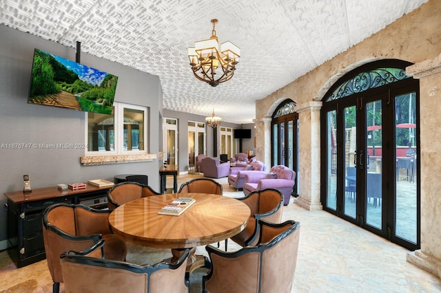 dining room with decorative columns, a notable chandelier, and french doors