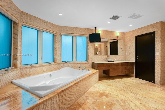 bathroom with vanity and tiled bath