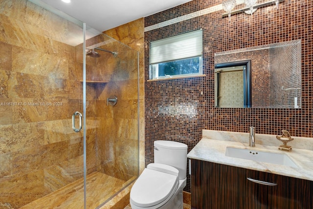 bathroom featuring vanity, toilet, tile walls, and a shower with shower door