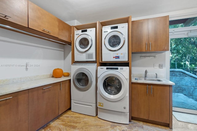 laundry area with sink, independent washer and dryer, cabinets, and stacked washing maching and dryer