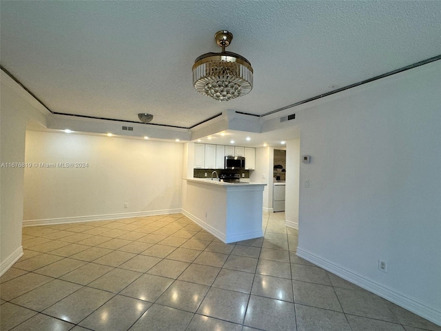 kitchen with sink, a textured ceiling, kitchen peninsula, white cabinetry, and light tile patterned floors