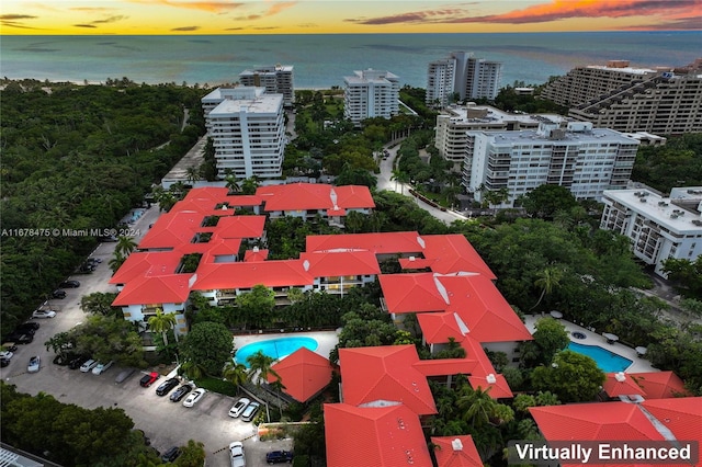 aerial view at dusk featuring a water view