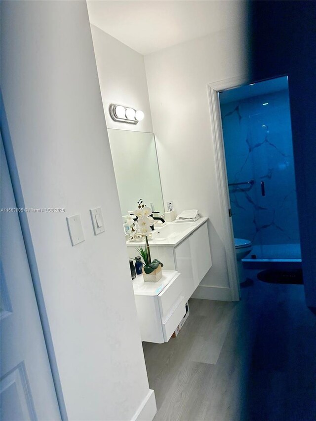 bathroom featuring toilet, vanity, and hardwood / wood-style flooring