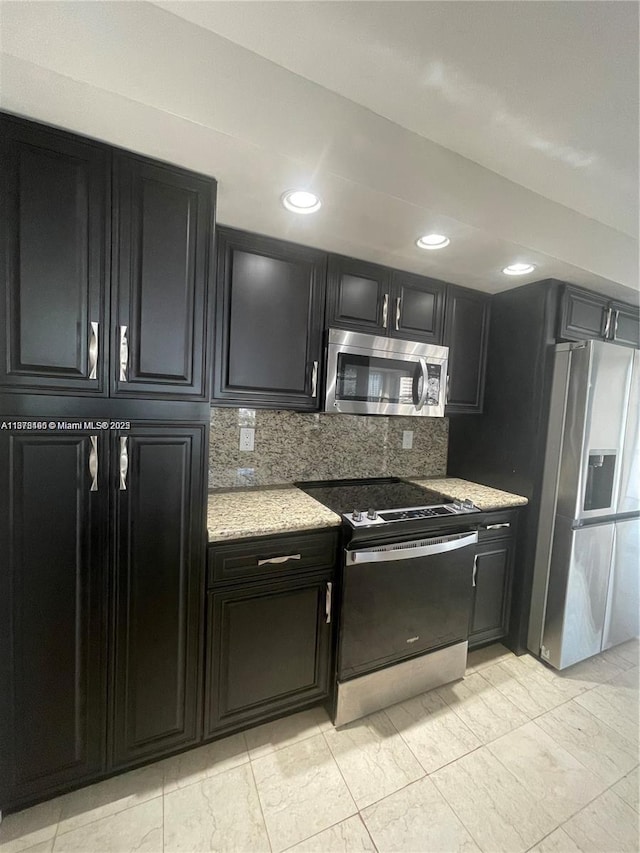 kitchen with decorative backsplash, light stone counters, and appliances with stainless steel finishes