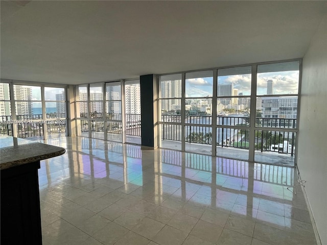 interior space with a wall of windows and light tile patterned floors