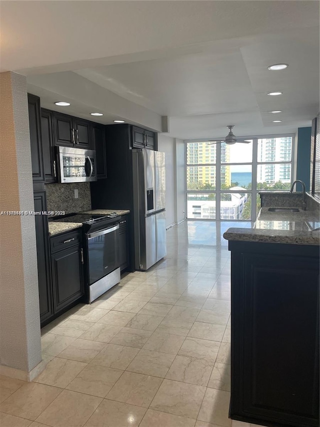 kitchen with tasteful backsplash, sink, dark stone counters, and appliances with stainless steel finishes