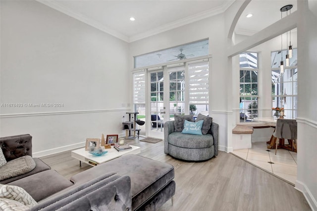 living room featuring crown molding, ceiling fan, light hardwood / wood-style floors, and french doors