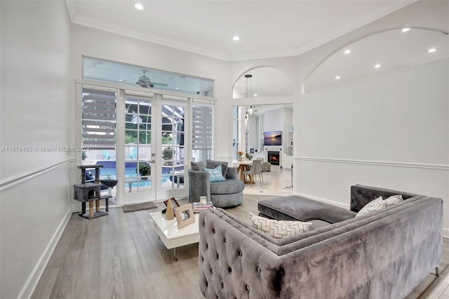 living room featuring ornamental molding, french doors, light wood-type flooring, and ceiling fan