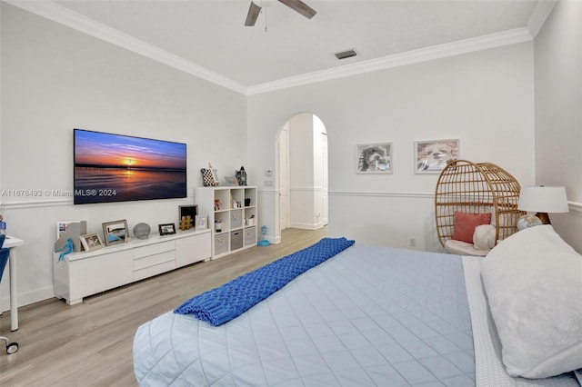 bedroom featuring light hardwood / wood-style flooring, crown molding, and ceiling fan