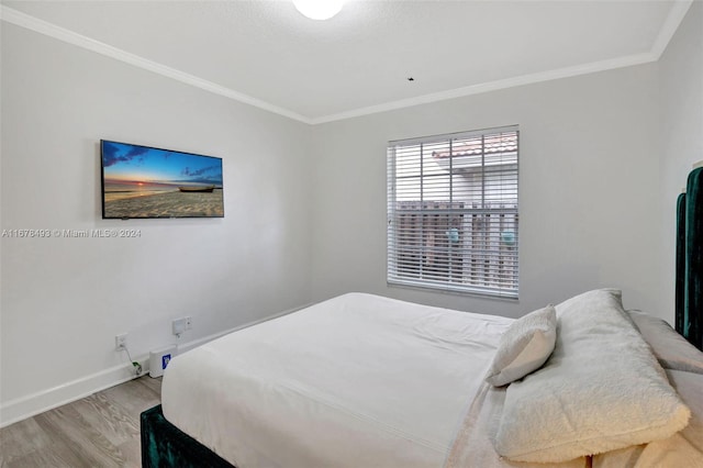 bedroom with light hardwood / wood-style flooring and crown molding