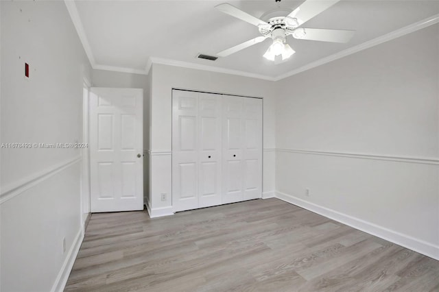 unfurnished bedroom featuring a closet, ceiling fan, crown molding, and light hardwood / wood-style floors