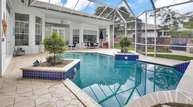 view of swimming pool with a patio, ceiling fan, and glass enclosure