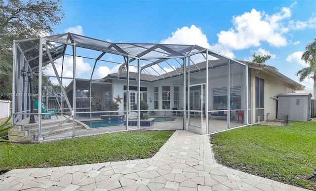 rear view of property with a yard, a patio area, and a lanai