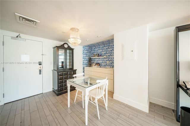 dining area with a chandelier and light hardwood / wood-style floors