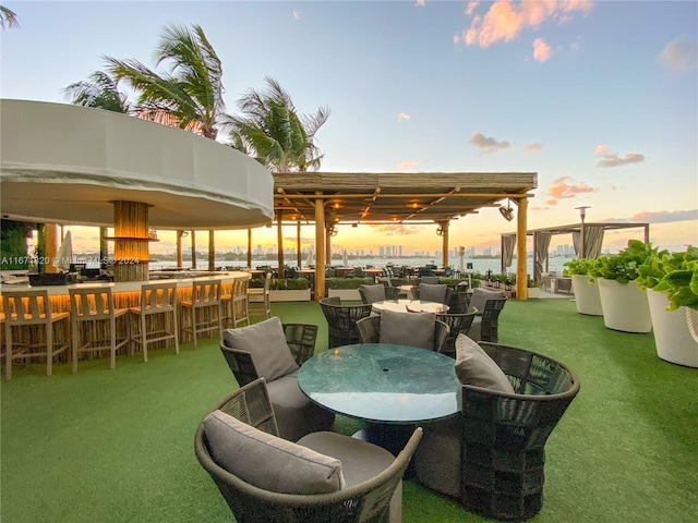 patio terrace at dusk featuring an outdoor bar