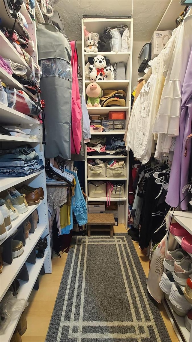 walk in closet with light wood-type flooring