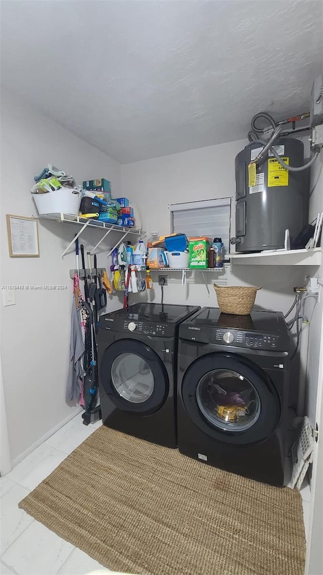 clothes washing area featuring washing machine and dryer and water heater