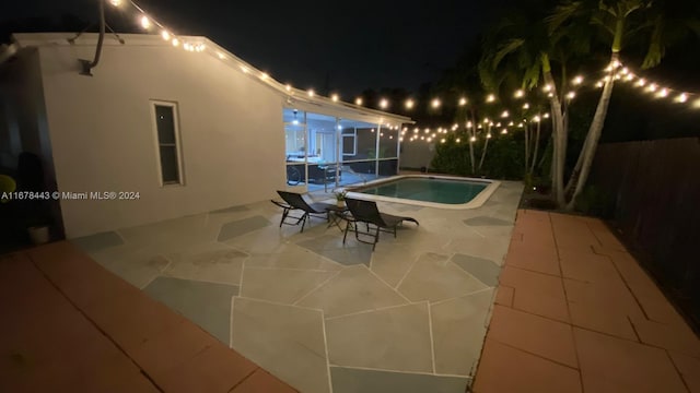 pool at twilight featuring a patio area