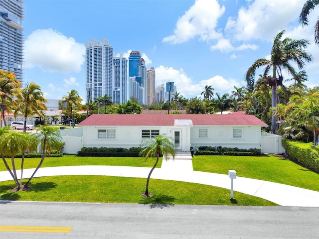 200 188th St, Sunny Isles Beach, FL 33160 - view of front of house featuring stucco siding, fence, a city view, and a front yard