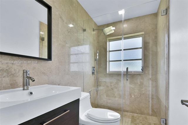 bathroom featuring toilet, walk in shower, vanity, and tile walls