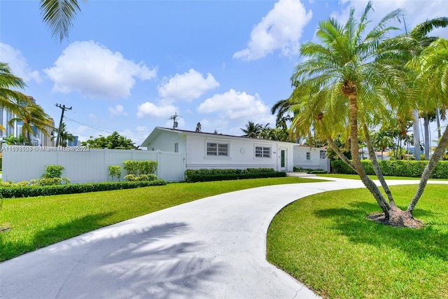 200 188th St, Sunny Isles Beach, FL 33160 - view of front of house with stucco siding, fence, a front yard, and curved driveway