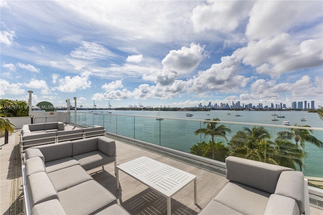 view of patio featuring a balcony, outdoor lounge area, and a water view