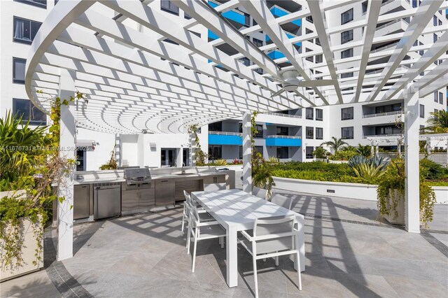 view of patio featuring a water view, sink, an outdoor kitchen, and a pergola