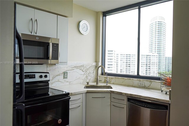 kitchen featuring sink, kitchen peninsula, white cabinetry, stainless steel appliances, and light hardwood / wood-style flooring