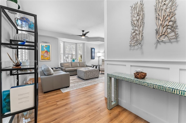 living room featuring wood-type flooring and ceiling fan