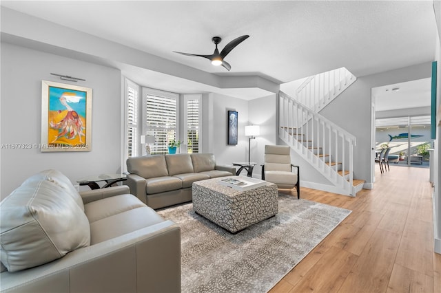 living room featuring hardwood / wood-style floors and ceiling fan