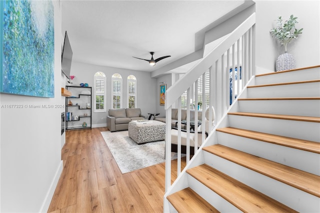 living room featuring light hardwood / wood-style flooring and ceiling fan