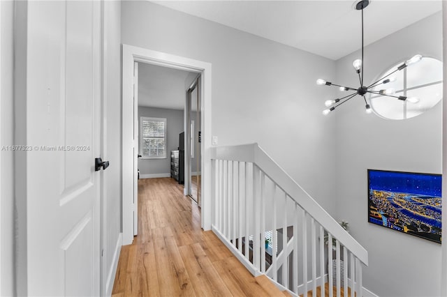 hallway featuring an inviting chandelier and hardwood / wood-style floors