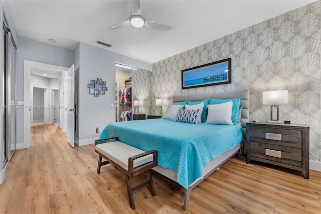 bedroom with a closet, light wood-type flooring, and ceiling fan