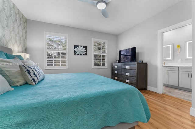 bedroom featuring ensuite bathroom, light hardwood / wood-style floors, and ceiling fan