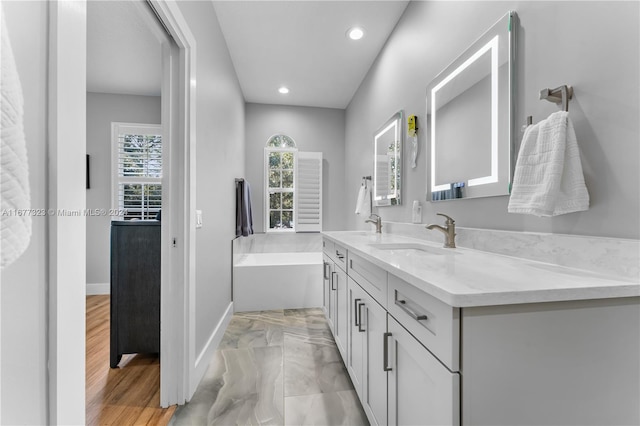 bathroom featuring vanity, a tub to relax in, and hardwood / wood-style floors