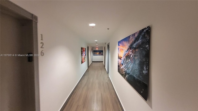 hallway with hardwood / wood-style flooring