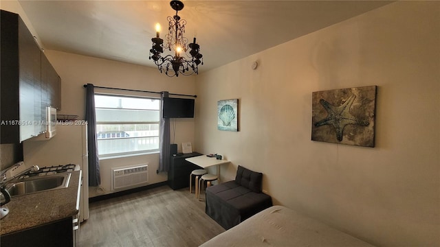 interior space featuring a notable chandelier, a wall mounted AC, sink, and light wood-type flooring