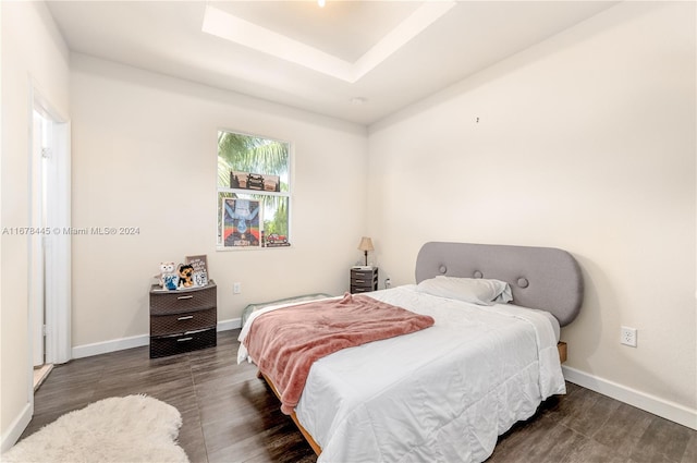 bedroom featuring a tray ceiling and dark hardwood / wood-style floors