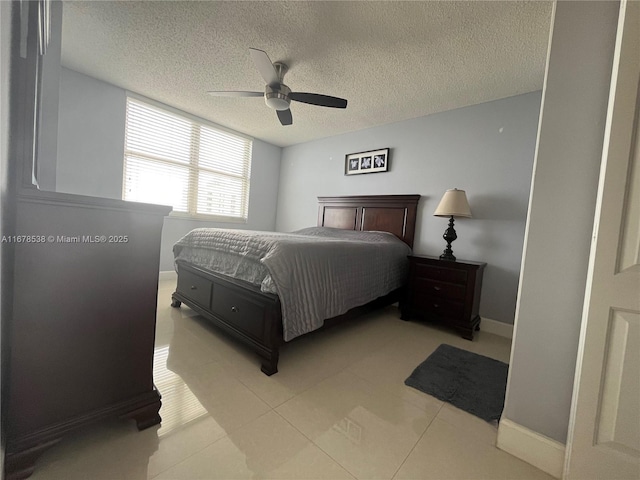 bedroom featuring a ceiling fan, a textured ceiling, and baseboards