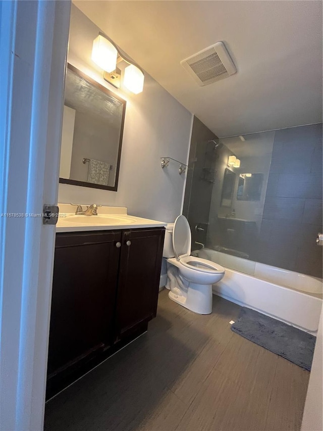 full bath with visible vents, toilet, wood finished floors, bathtub / shower combination, and vanity