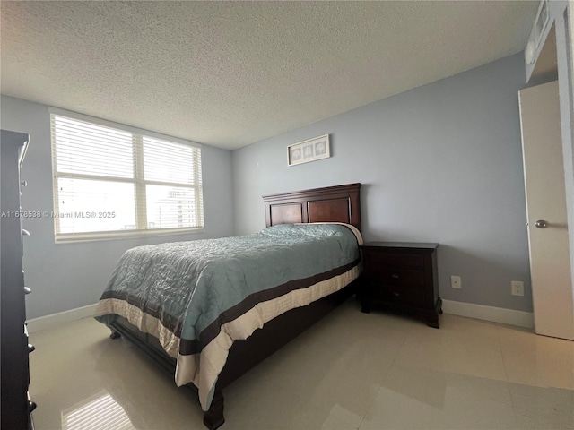 bedroom with a textured ceiling and baseboards