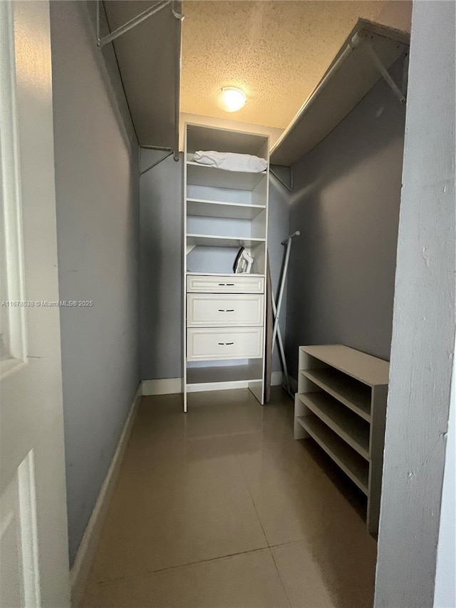 spacious closet featuring dark tile patterned floors