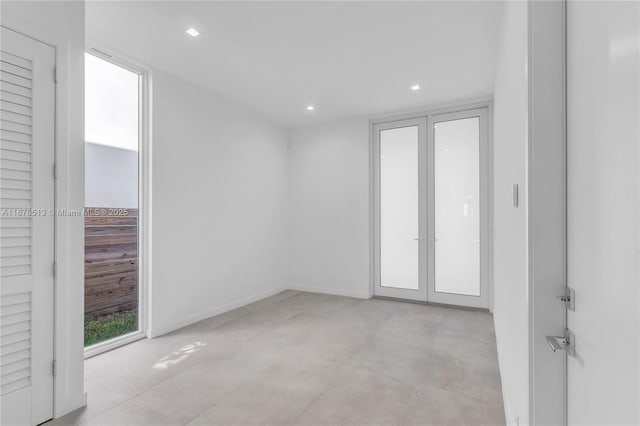 spare room with recessed lighting, french doors, and baseboards