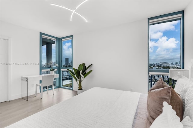 bedroom featuring expansive windows, light hardwood / wood-style flooring, and multiple windows