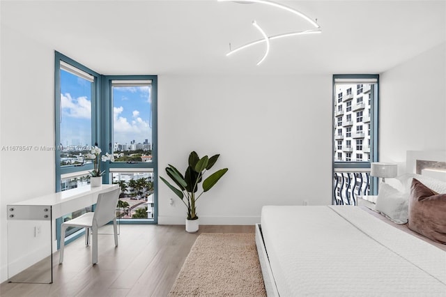 bedroom featuring hardwood / wood-style flooring and expansive windows