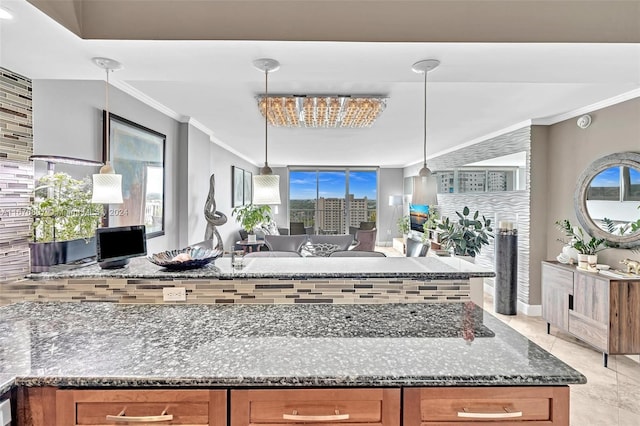 kitchen with dark stone countertops, a wealth of natural light, and pendant lighting