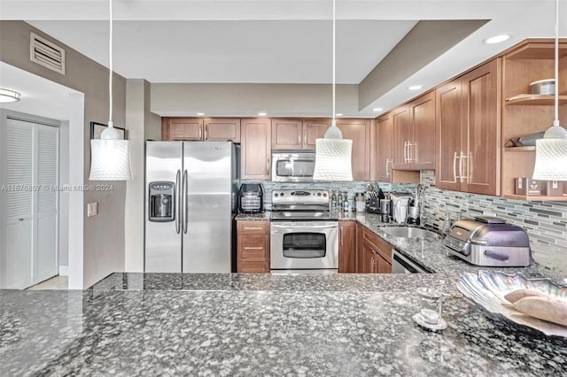 kitchen with backsplash, appliances with stainless steel finishes, dark stone countertops, sink, and decorative light fixtures